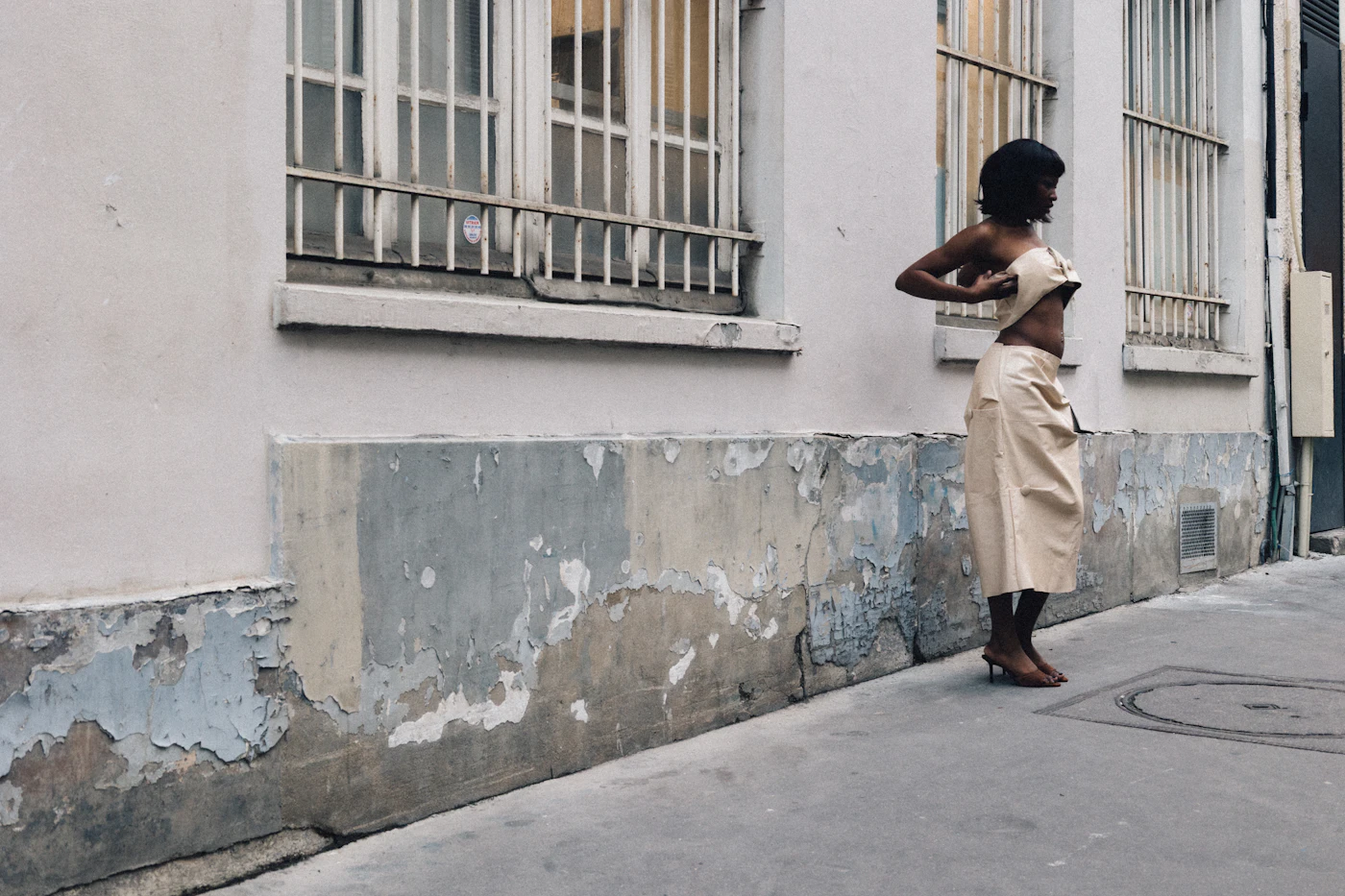 Woman adjusting clothing on a street